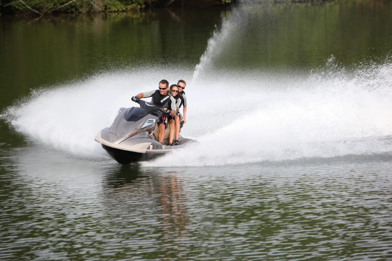 three people on a jet ski being pulled by a boat