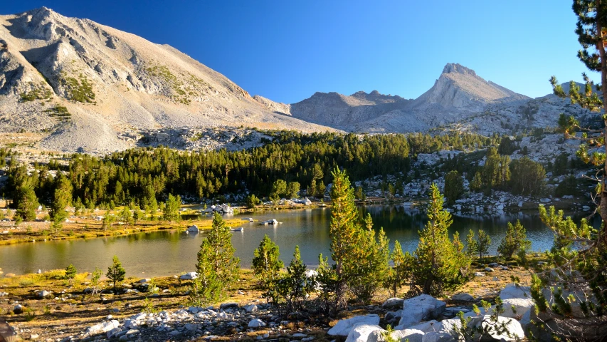 a mountain lake surrounded by snow covered mountains