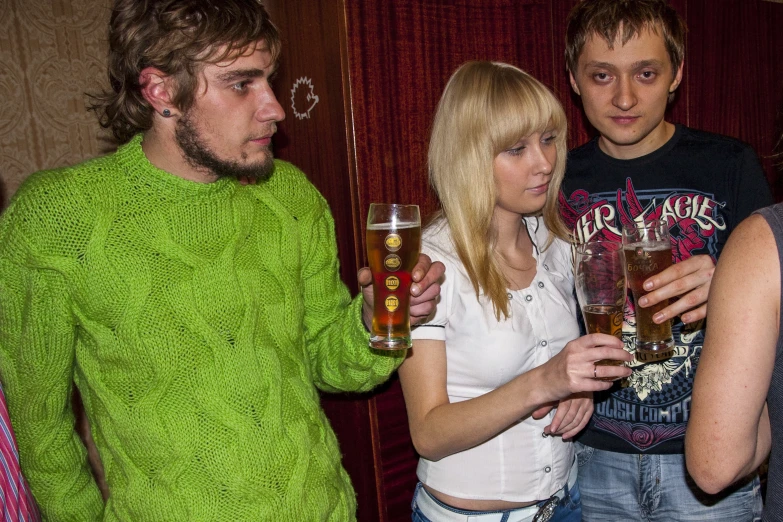 a group of people are drinking beverages in a bar