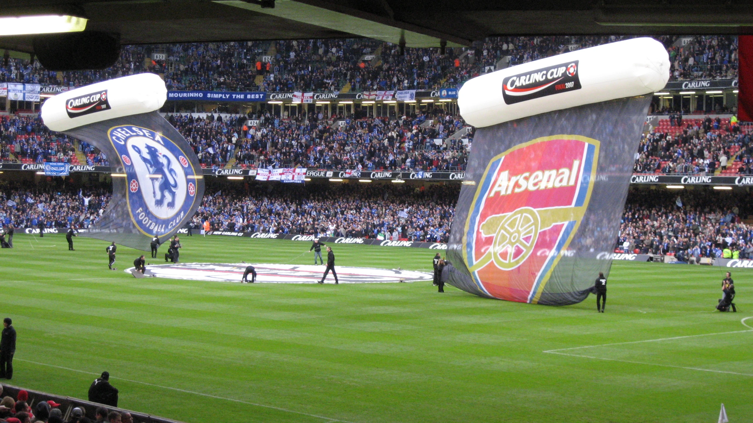 a field full of people with several giant fake objects on it