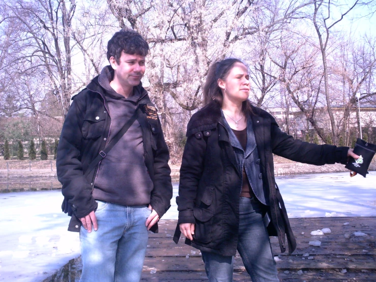 a man standing next to a woman in a park