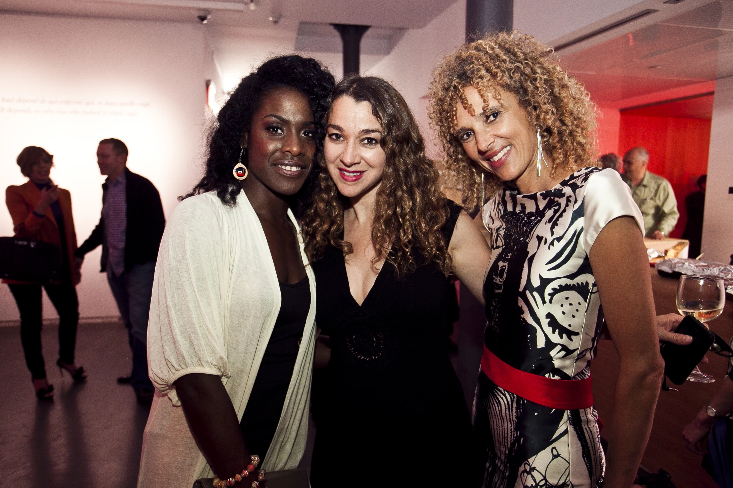 three woman standing together and smiling while posing for a picture