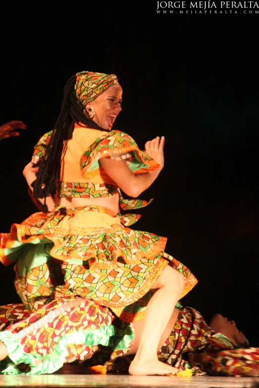 a woman in colorful clothes with people clapping