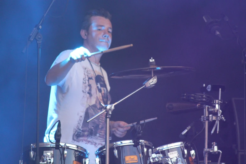 drummer holding up his drums on stage