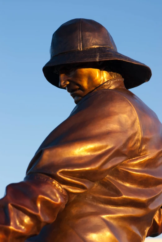 a bronze statue with a black hat and red gloves