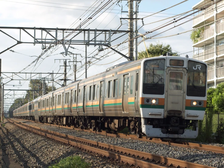 a commuter train on tracks with wires above