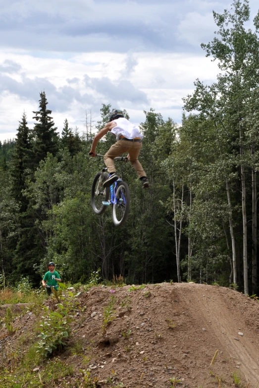 the man is riding his bike over a hill