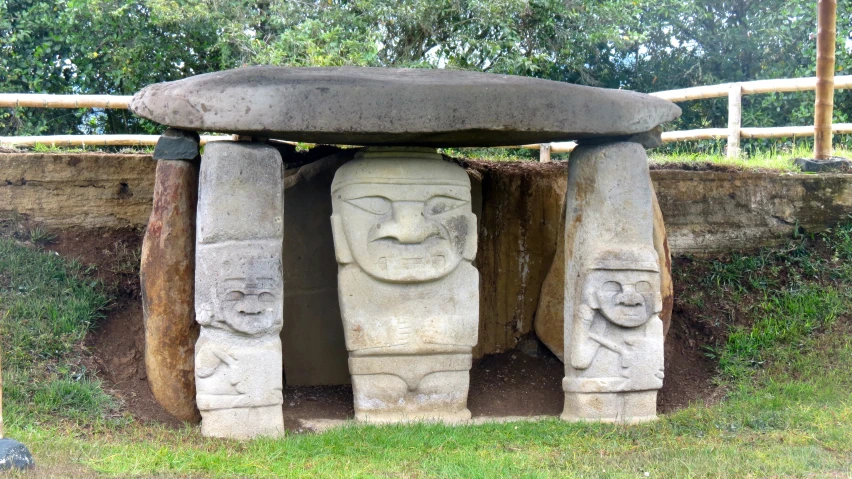 large stone sculpture surrounded by grass in grassy area