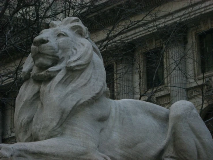 a statue of a large stone lion is outside