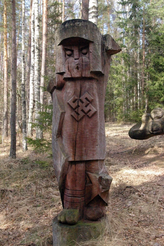 a wooden carving in the middle of a forest