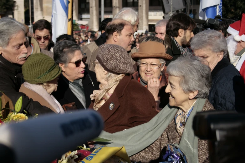 a crowd of people standing around each other and wearing hats