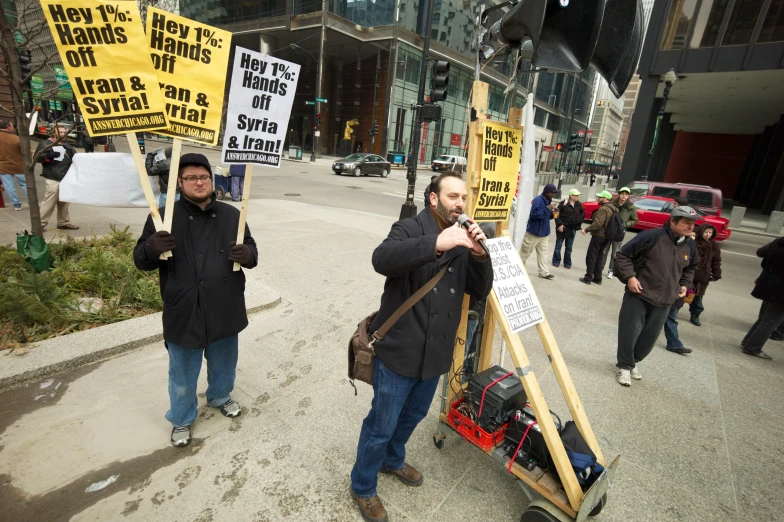 two protesters holding up signs on the street