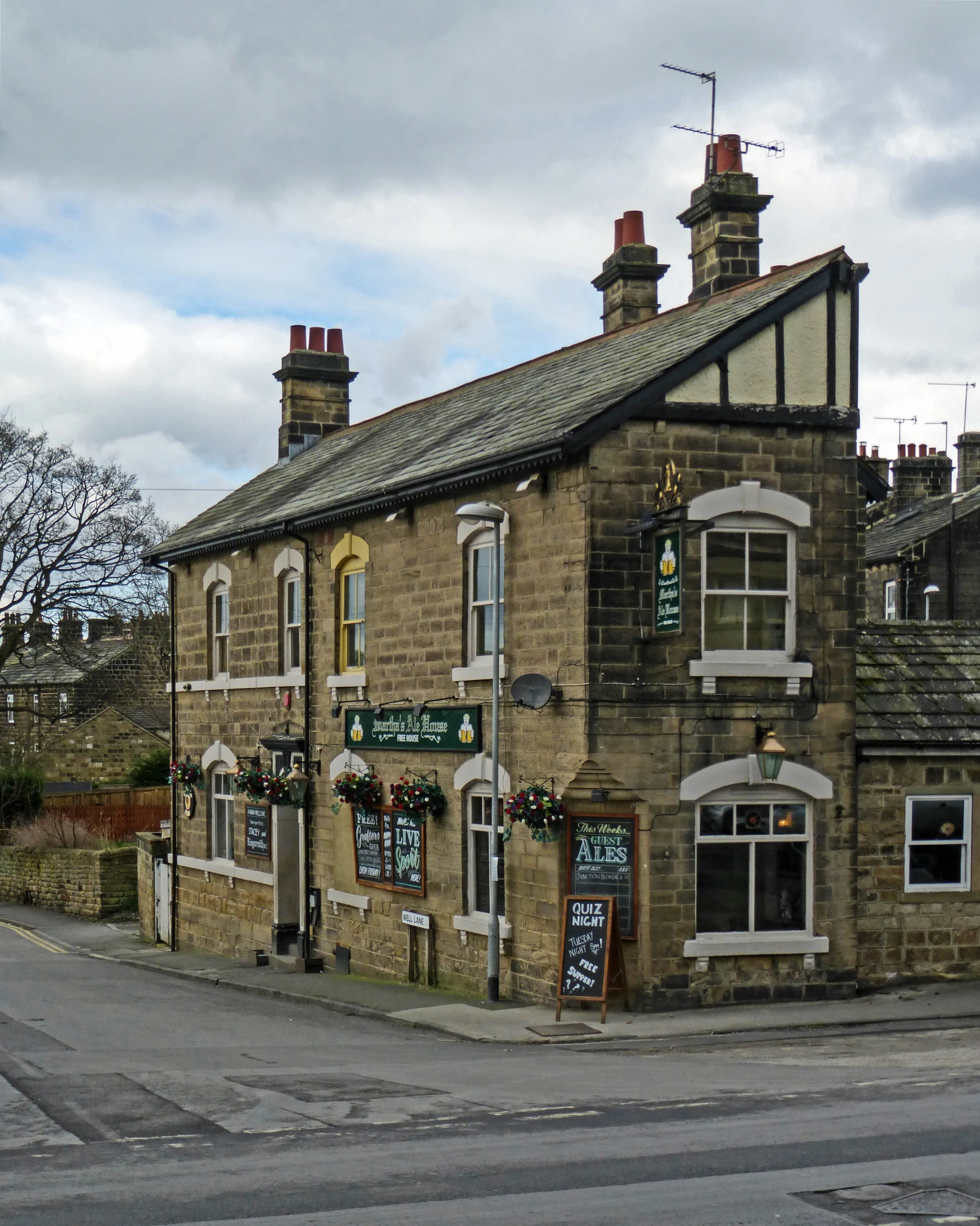 a stone building with windows, bushes and an awning