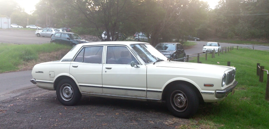 a small old fashioned car sitting in a parking lot