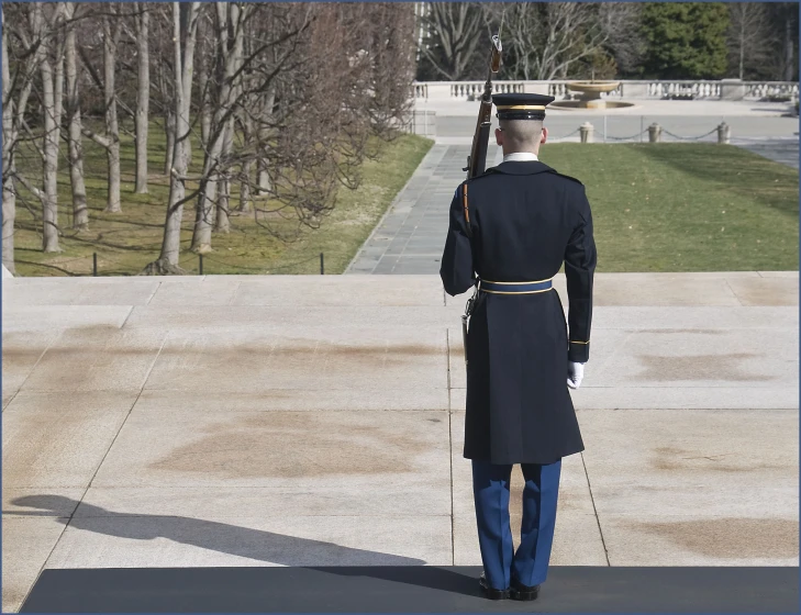 a man in uniform standing outside on a sunny day