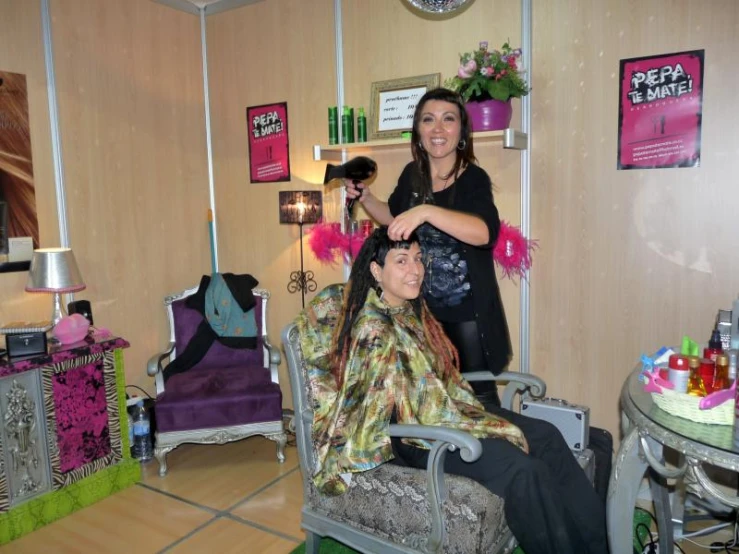 two women who are sitting in chairs getting hair done