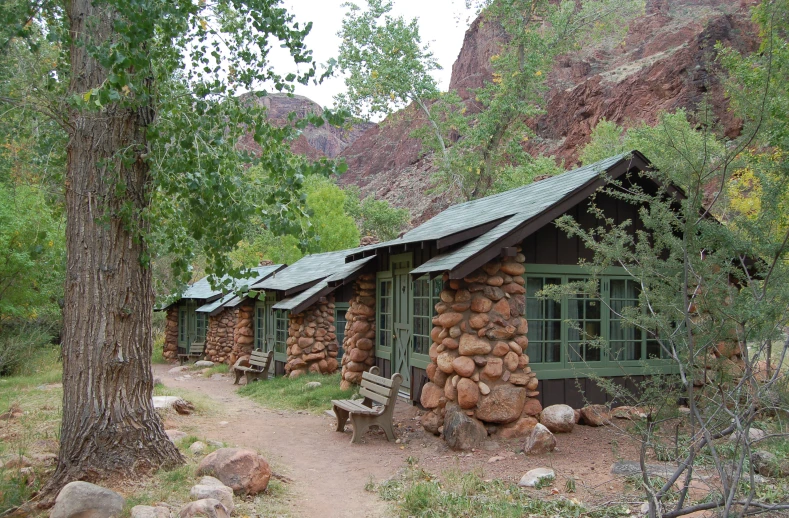 the cabin is made of stones and green trim