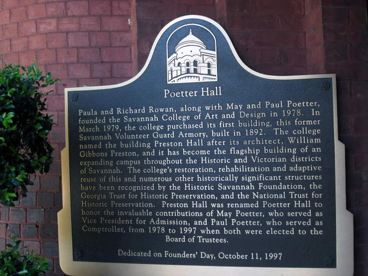 a plaque is displayed in front of a brick building