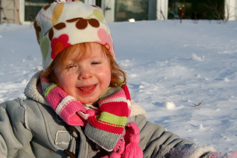 a child outside playing in the snow on a sunny day