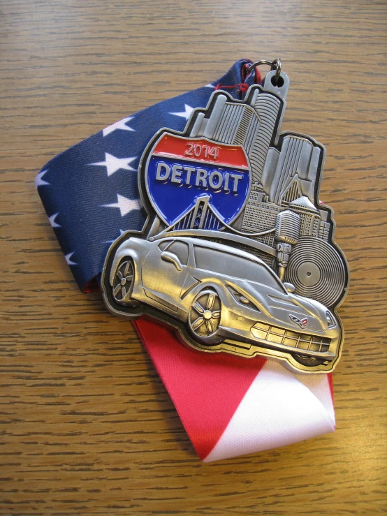 a medal with an american flag next to a race car