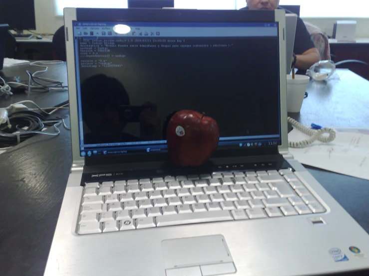 an open laptop with an apple sitting next to it