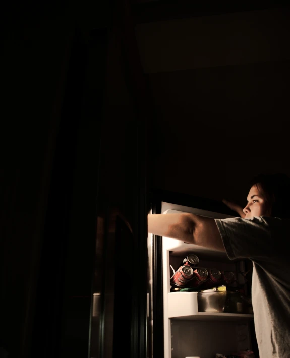 a man is leaning into a fridge while the man stands inside