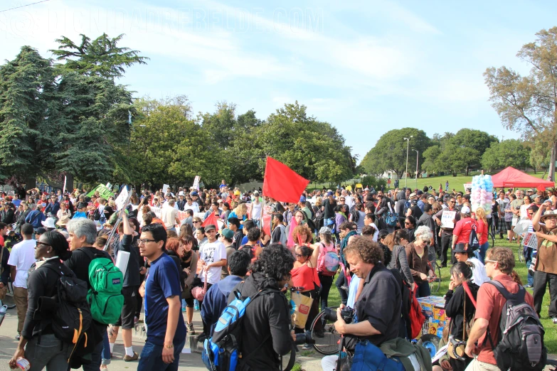 a group of people stand together in the park with signs on it