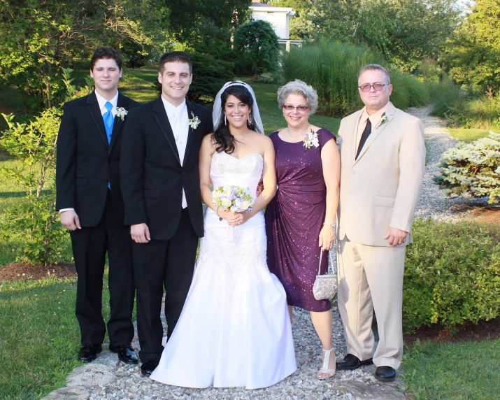 a bride and groom stand with two couples in their wedding party attire