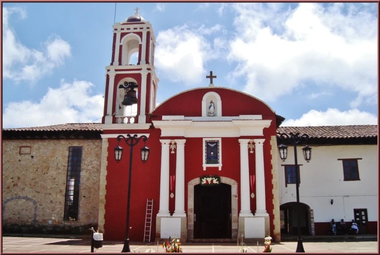 a red and white church in front of a brown building