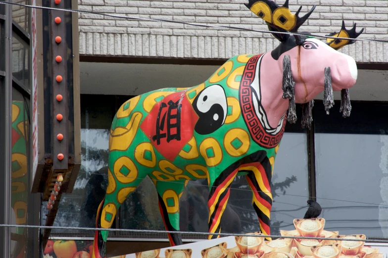 a statue of a painted horse hanging in front of a building