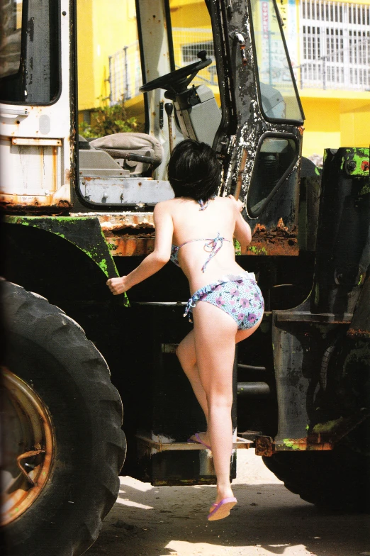 a little girl standing next to a tractor