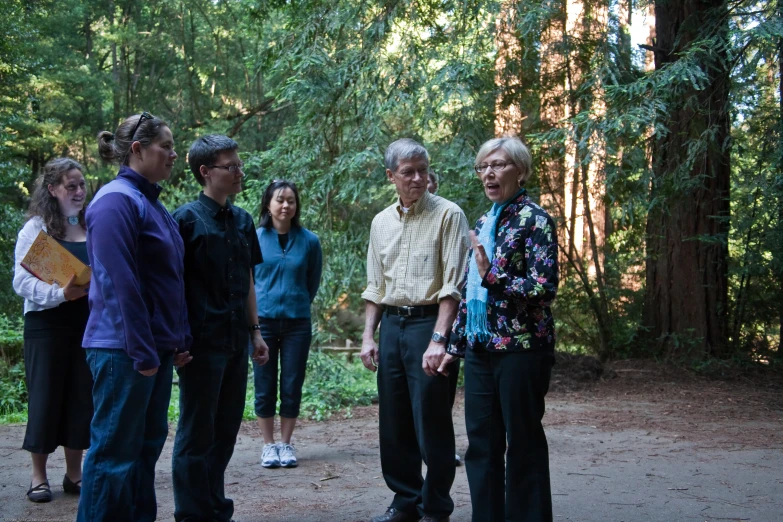 a group of people are standing together in the woods