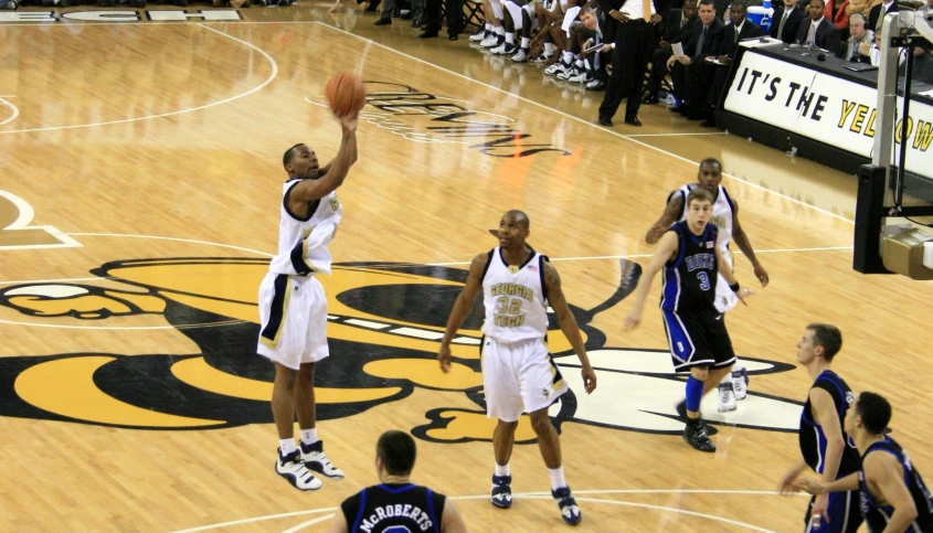 basketball players on a court playing basketball as fans watch