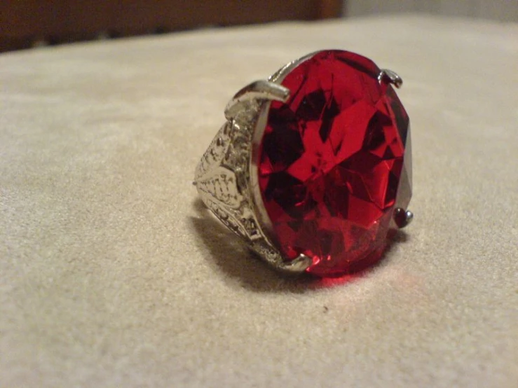 a close up of a red diamond on a white table