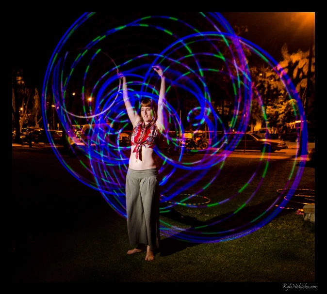 a woman with her hands out and spinning light