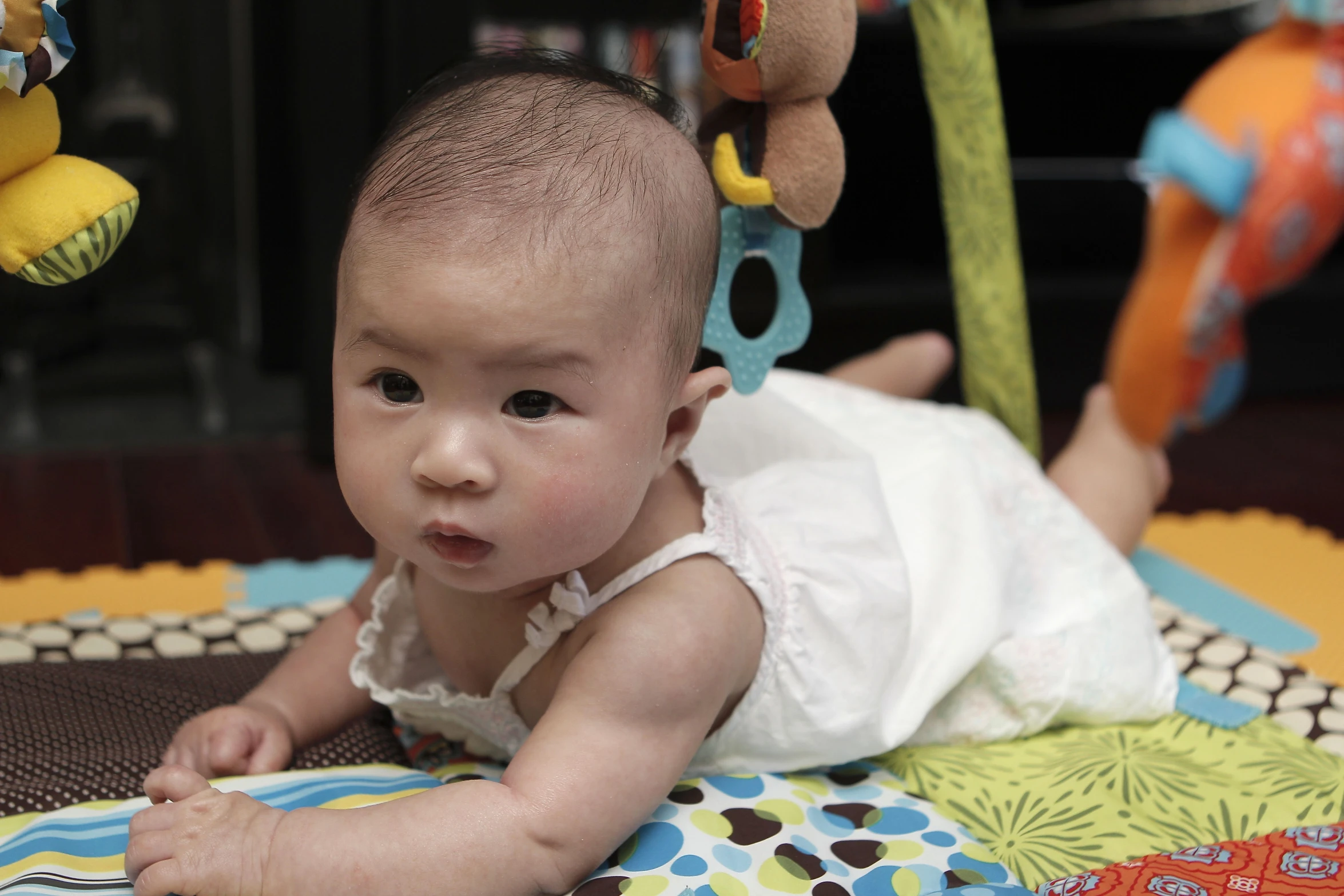 an adorable baby plays with toys on a blanket