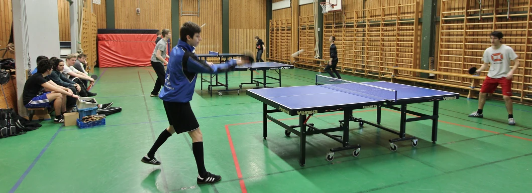 a man is hitting a ping pong ball on the court