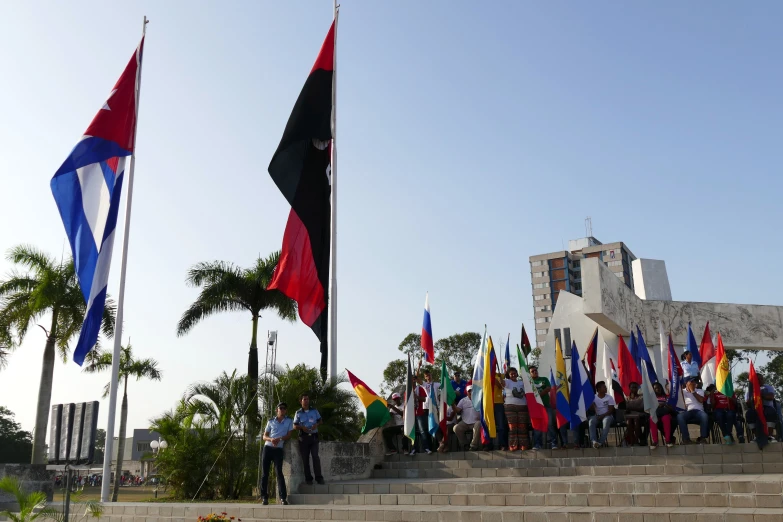 people standing on steps and flags outside a building