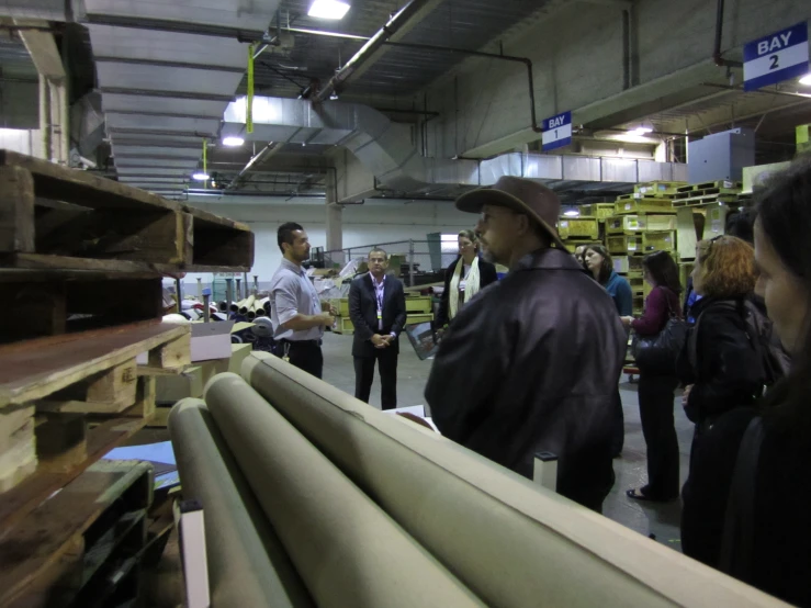 people in a factory looking at wooden boards