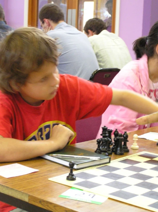 two children playing chess in an office setting