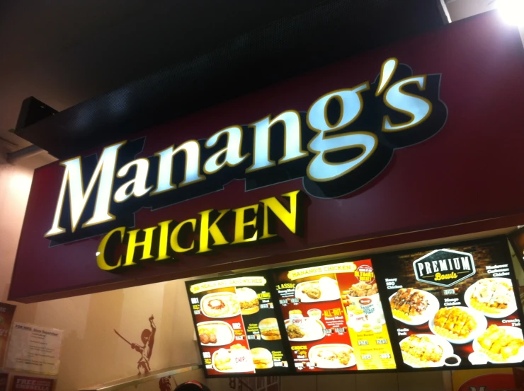 a manang's chicken restaurant sign at night