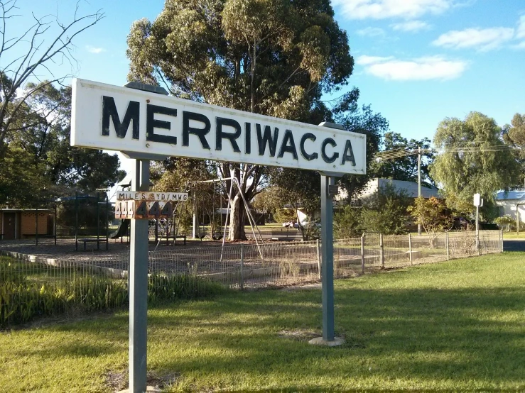 a white sign reading merrim waca sitting on top of a field