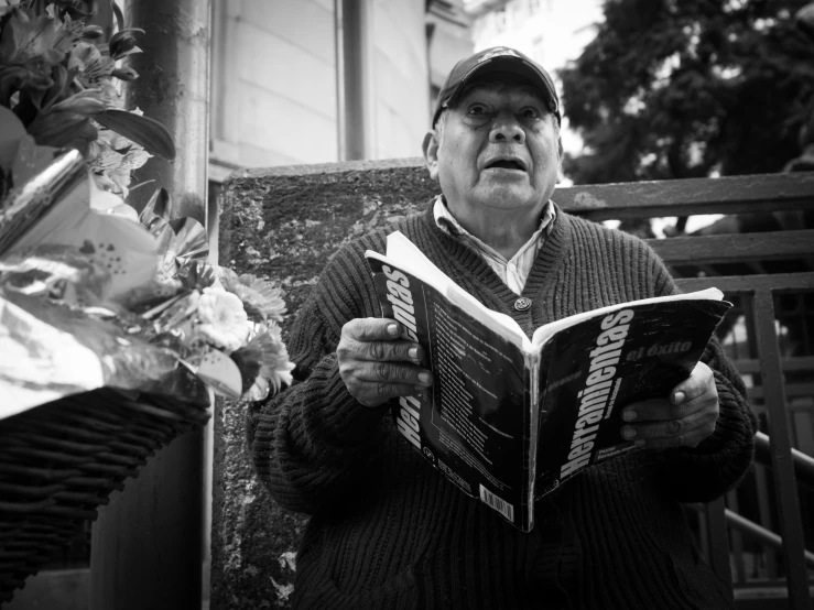 an older man in black and white reads a magazine