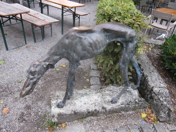 a sculpture of a dog is standing over a fence