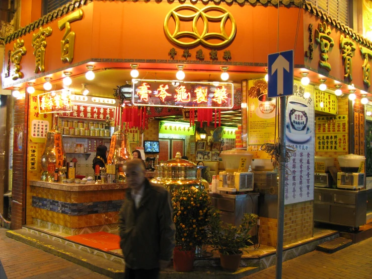 a man is walking past a small shop