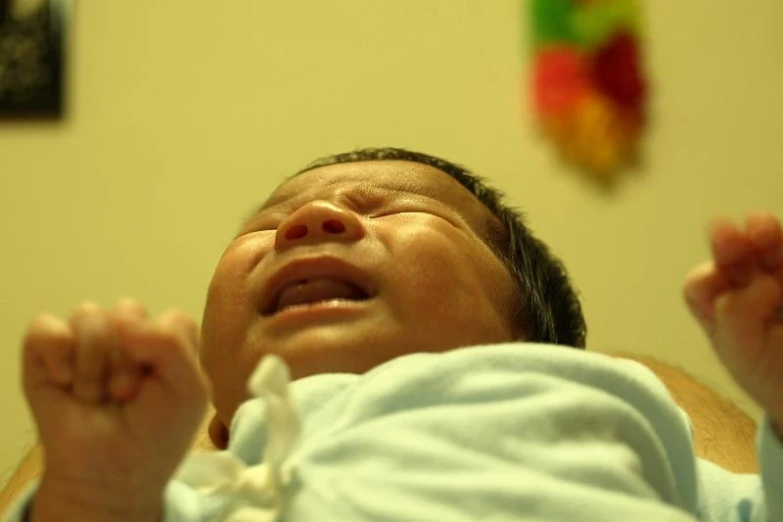 baby smiling while looking at camera in room