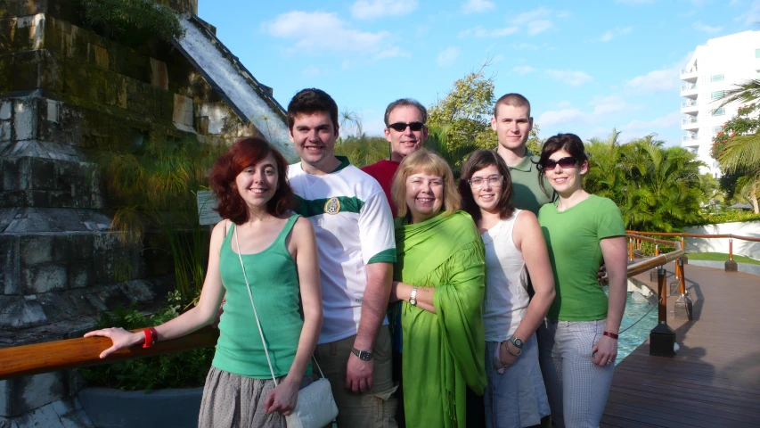 a group of people posing on a wooden bridge