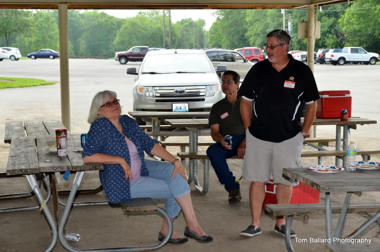 the group of people are sitting at the picnic table