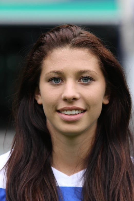 a young lady is smiling and wearing long hair