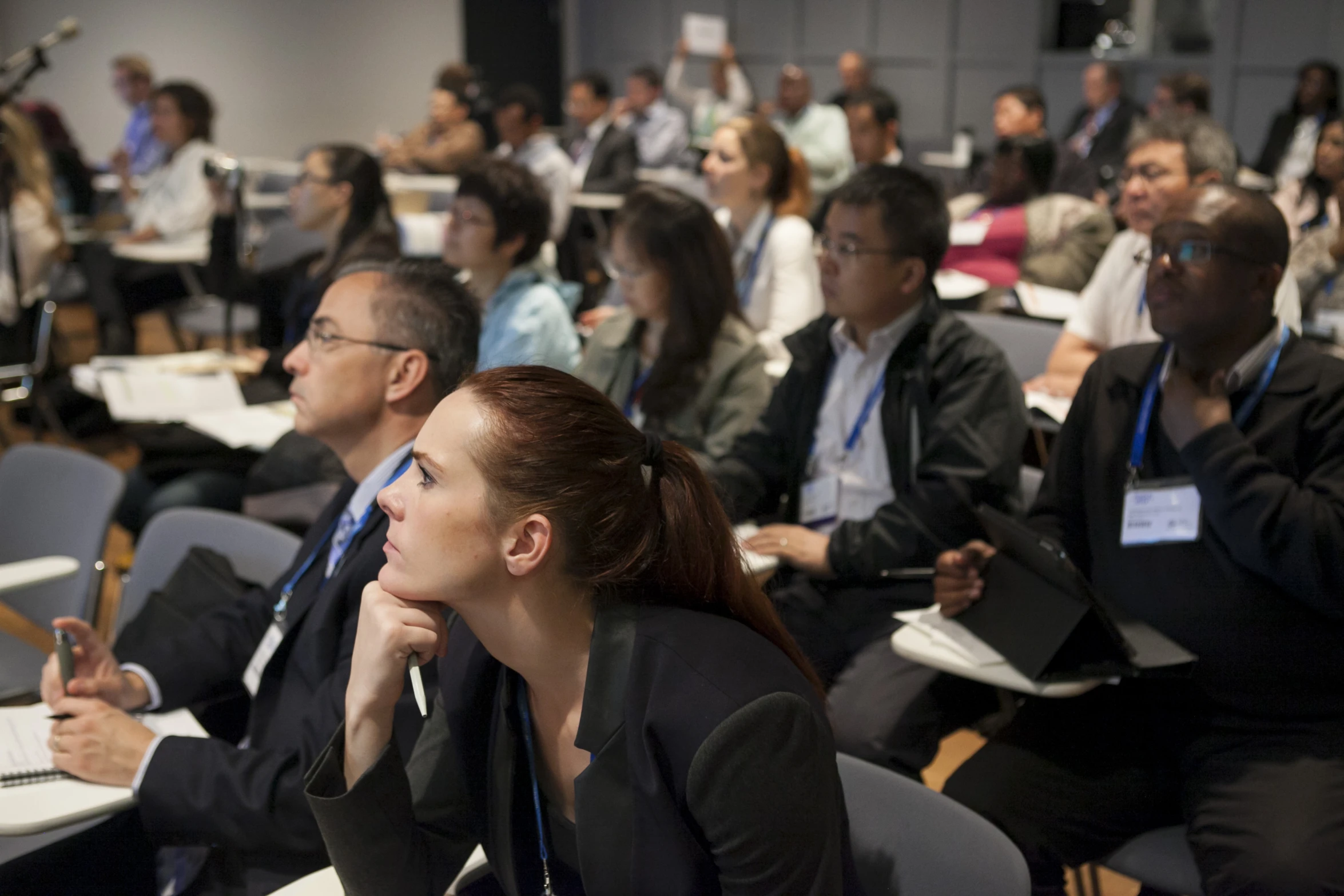 group of people sitting in an auditorium looking to their left